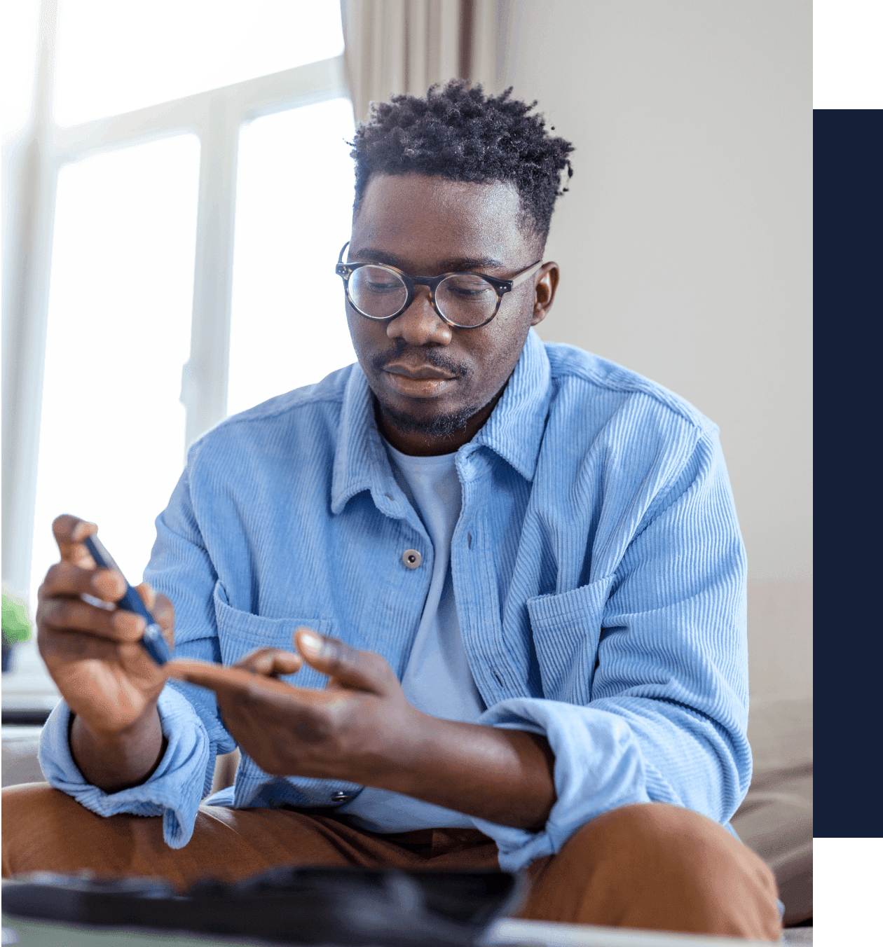 A man sitting on the floor looking at his phone.